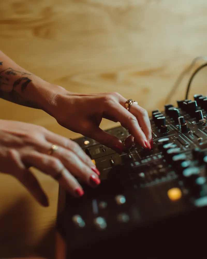 Hands on the faders of a mixer
